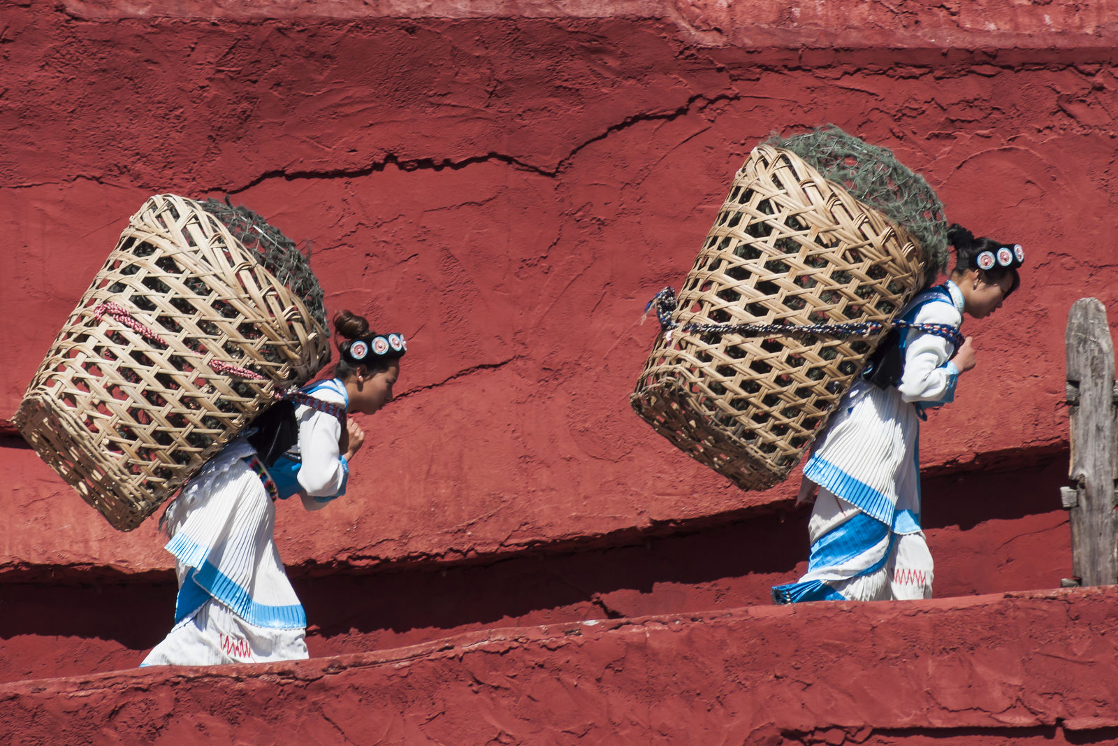 Lijiang Yunnan China Naxi people carrying baskets b